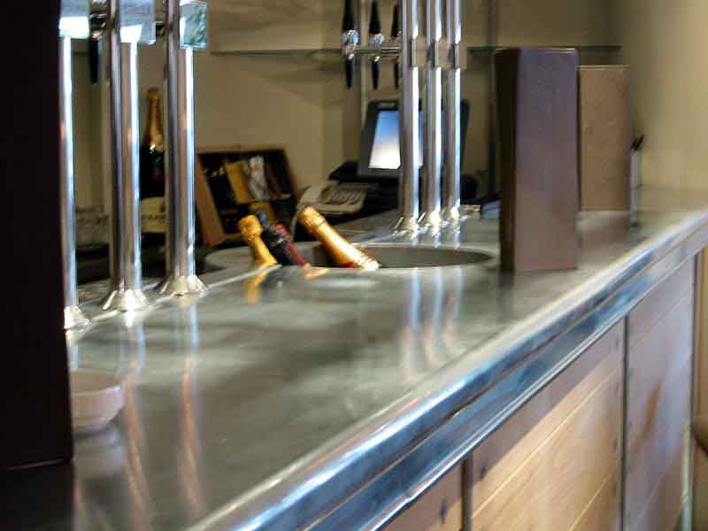 A stainless steel bar with bottles of wine on it