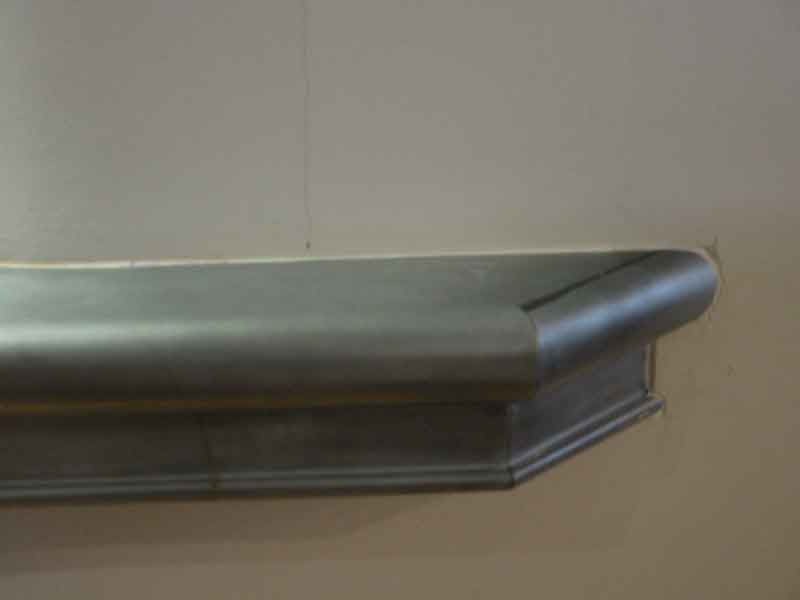 A close up of a metal railing on a wall.