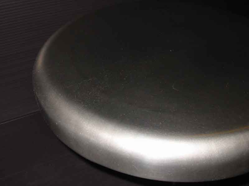 A close up of a metal object on a black surface.