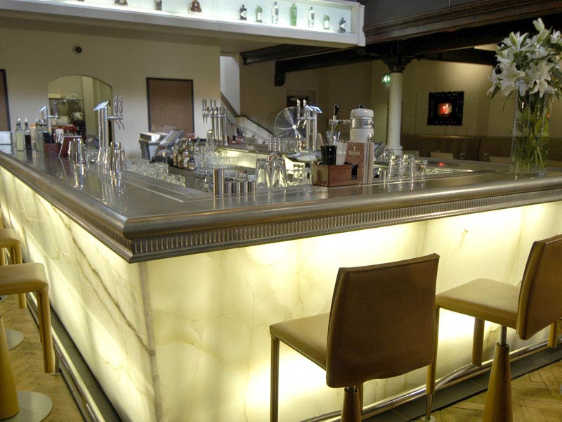A bar with two chairs and a vase of flowers