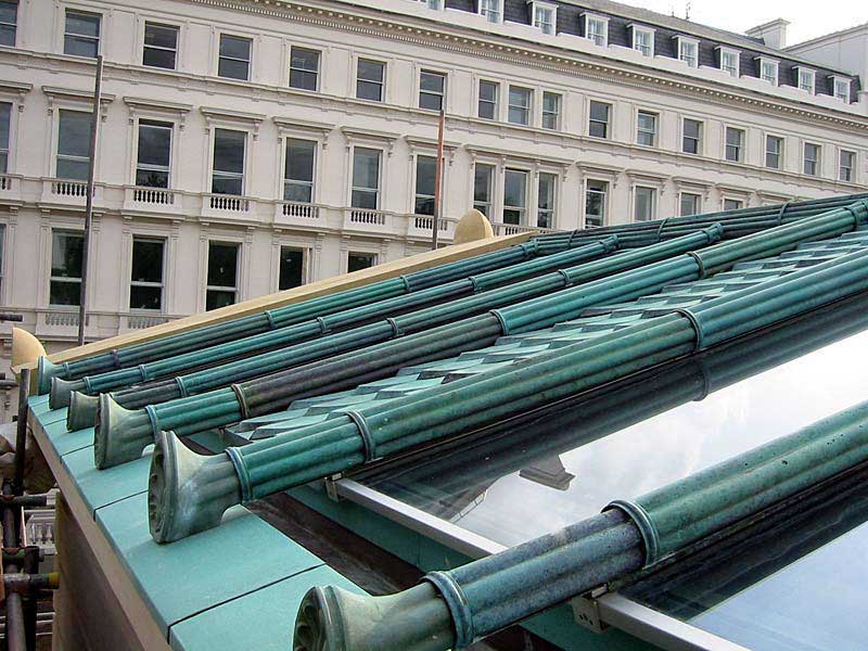 A roof with a lot of green pipes on it