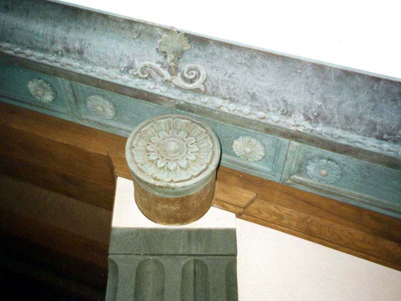 A close up of a roof with a circular decoration on it.