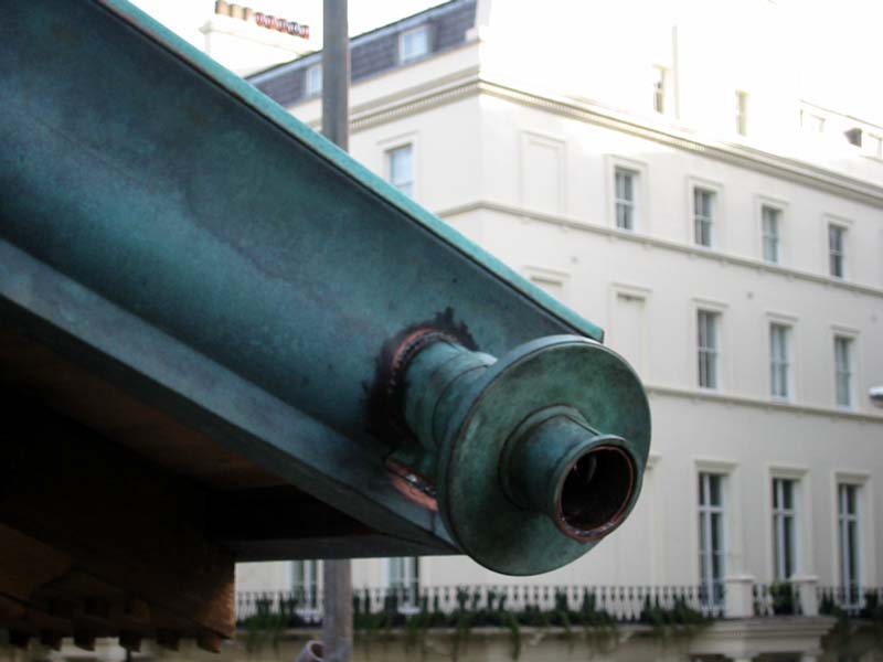 A green pipe with a white building in the background