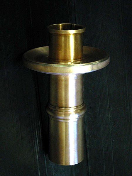 A brass object is sitting on a black surface