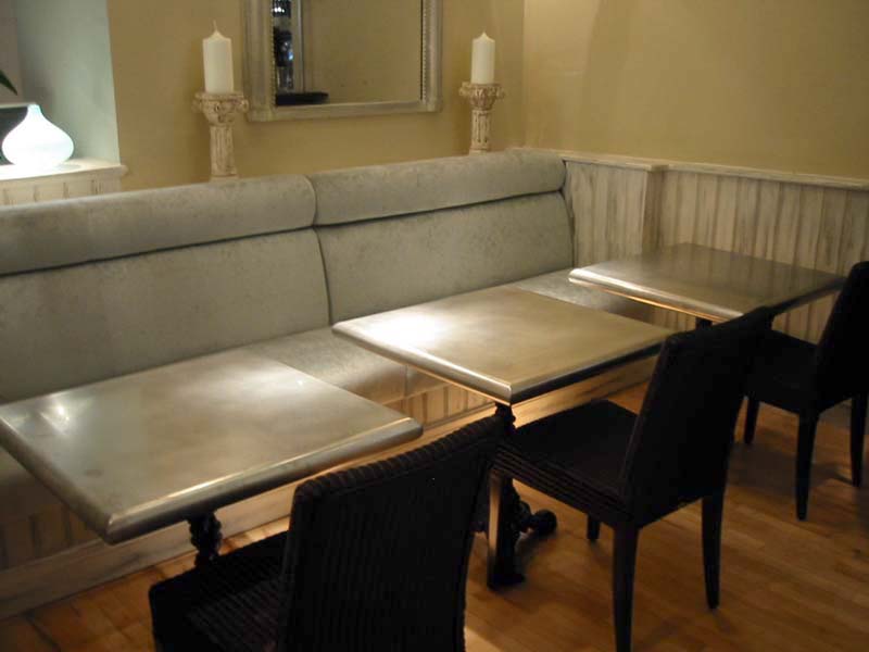 A dining room with tables and chairs and a couch