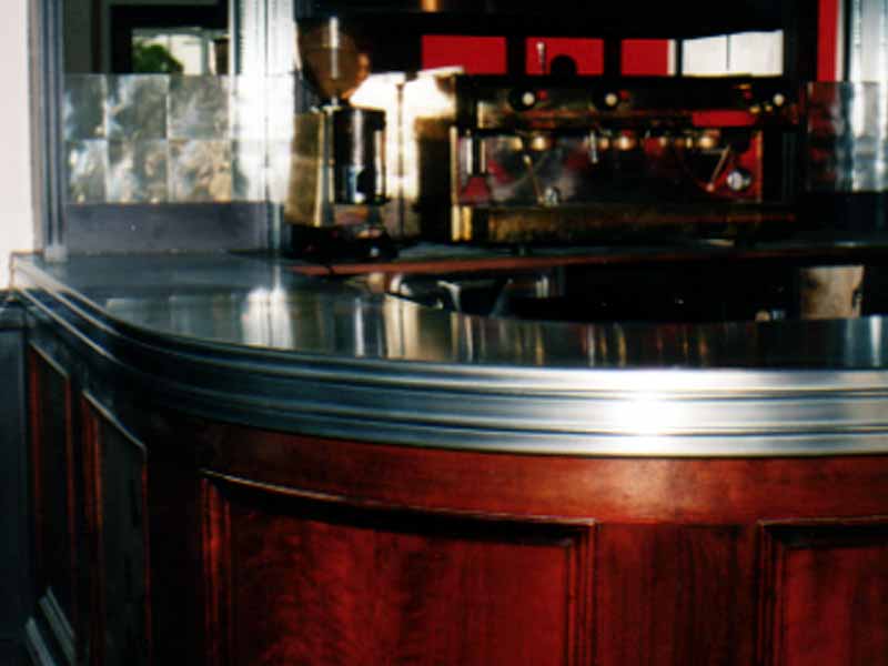 A wooden bar with a stainless steel counter top