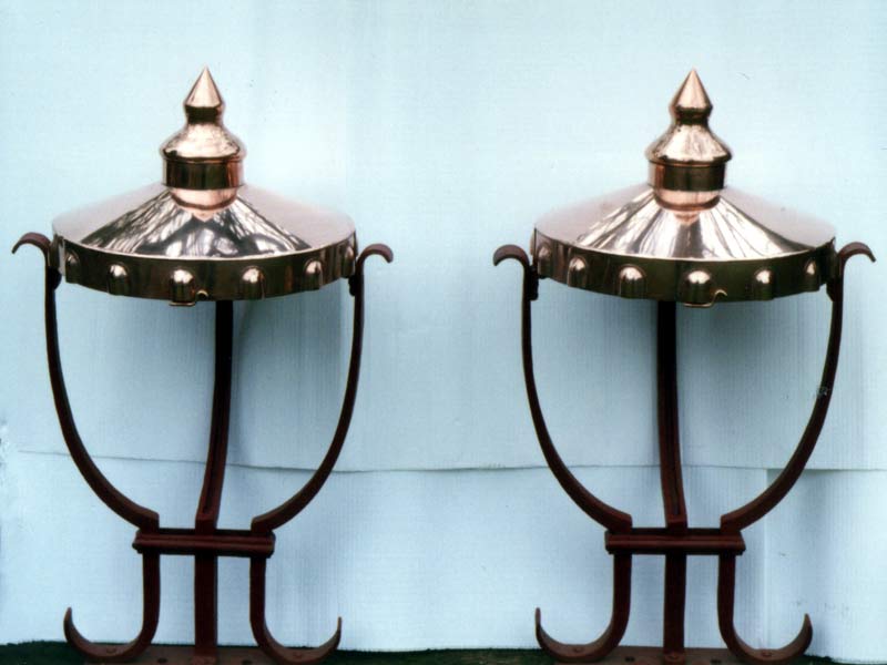 A pair of copper lamps with the letter j on them