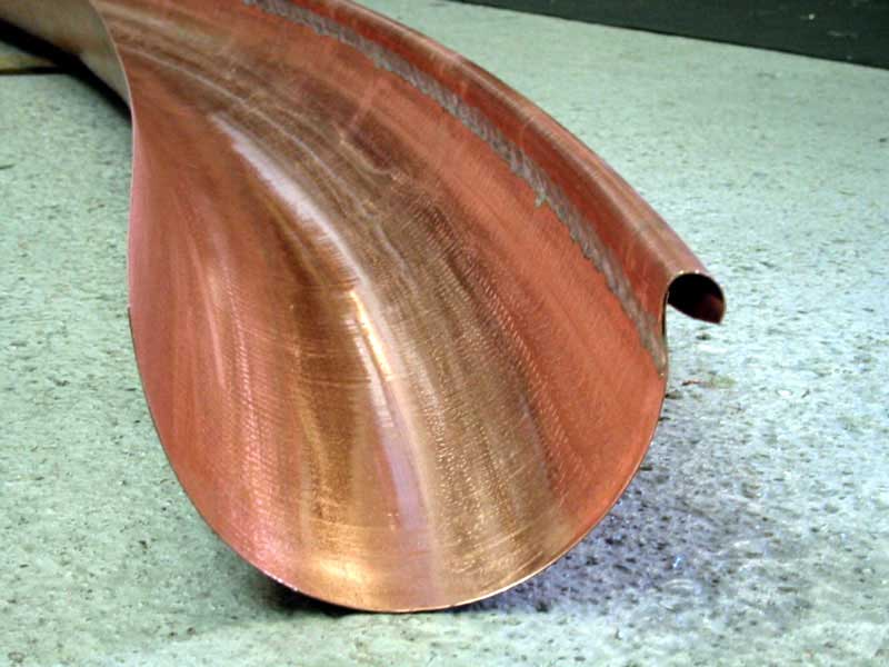 A close up of a copper pipe on a concrete surface