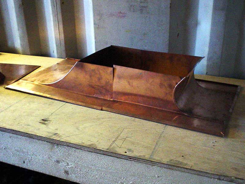 A piece of copper is sitting on top of a wooden table.