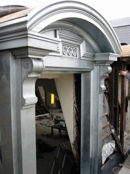 A man is working on a building with a metal archway