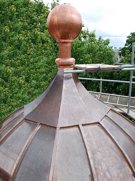 A copper dome with a copper ball on top of it.