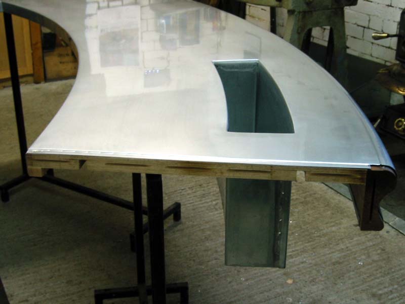 A curved metal table with a hole in the middle