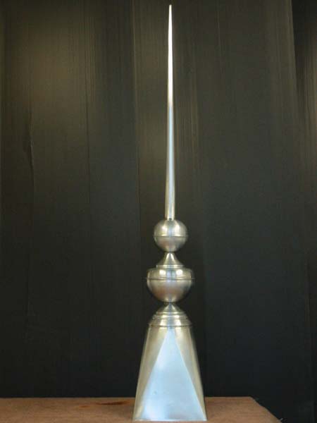 A tall metal object is sitting on a wooden table.