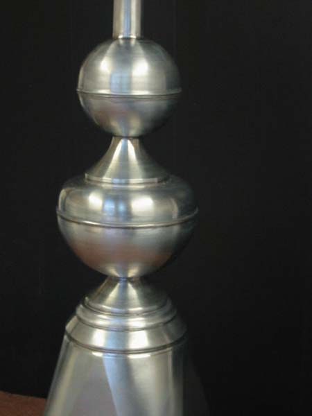 A silver object is sitting on a table in front of a black background.