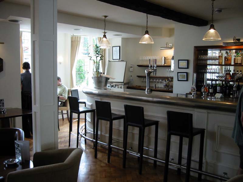 A bar in a restaurant with stools and chairs