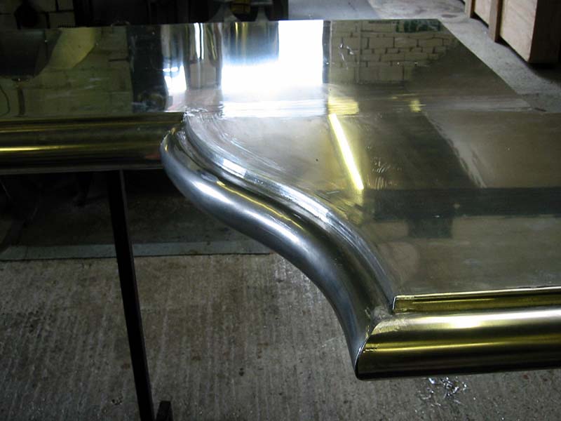 A stainless steel table with a curved edge