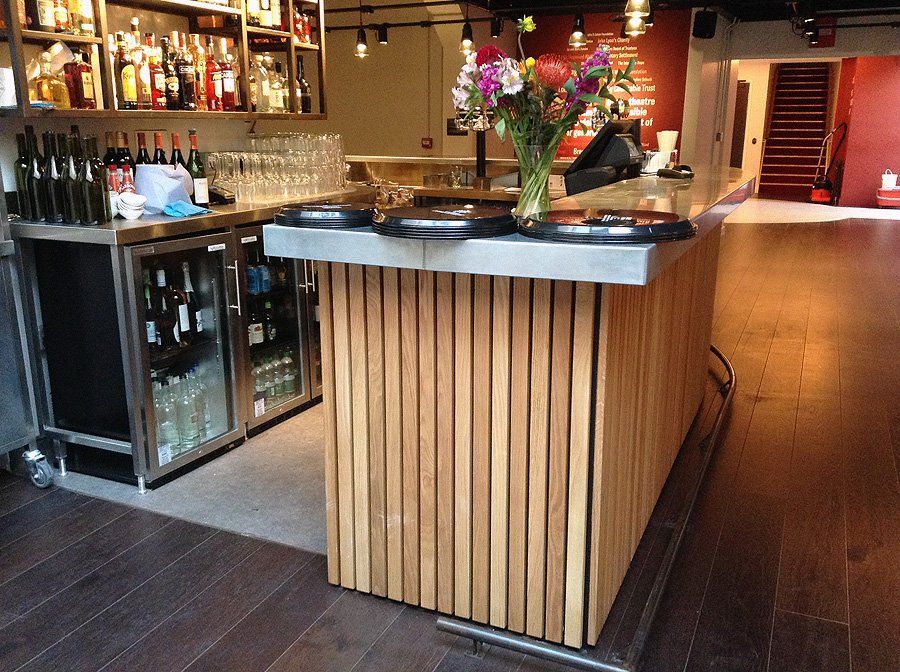 A bar with a vase of flowers on top of it