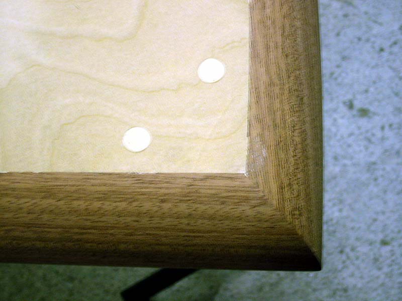 A close up of a wooden table with two holes in it