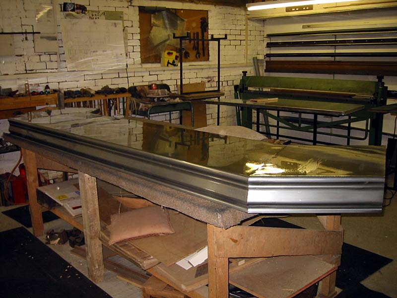 A large piece of metal is sitting on a wooden table in a workshop