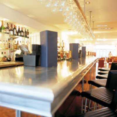 A bar in a restaurant with a stainless steel counter top
