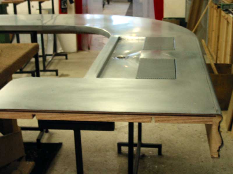 A wooden table with a metal top in a room
