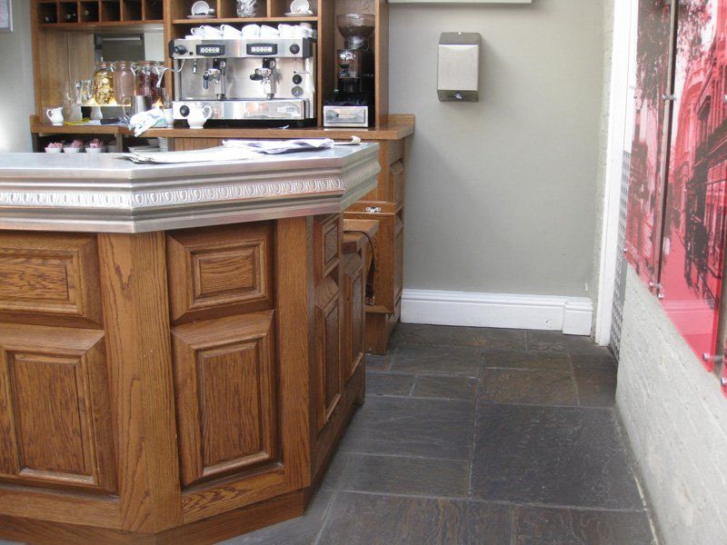 A wooden counter with a coffee machine in the background