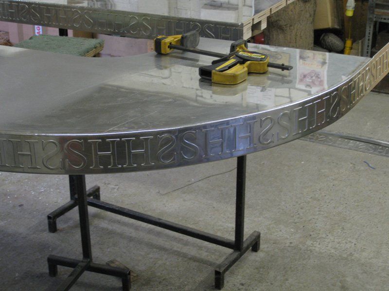 A stainless steel table with the word hush on it