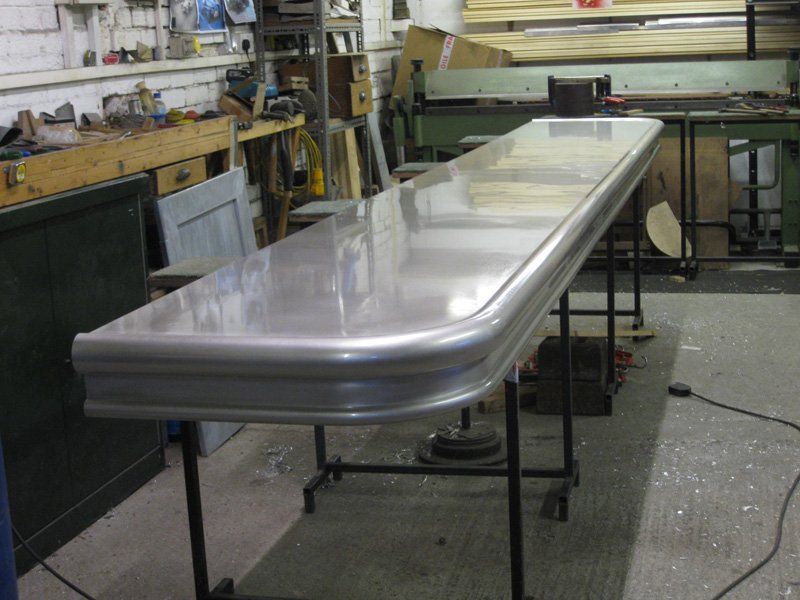 A long stainless steel table is sitting in a workshop