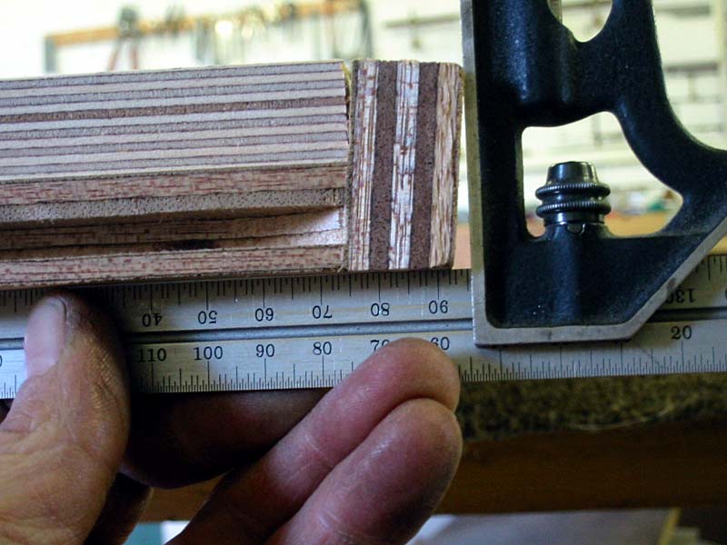 A person is measuring a piece of wood with a ruler