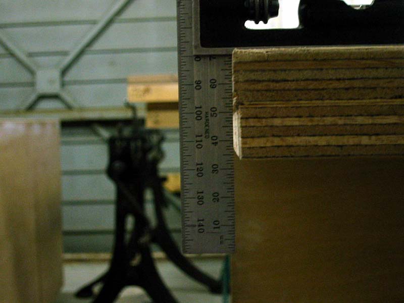 A metal ruler is sitting on top of a piece of wood