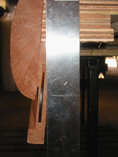A piece of wood is sitting next to a metal bar