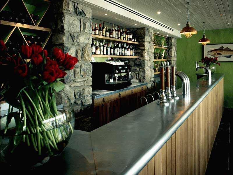 A bar with a vase of flowers on the counter