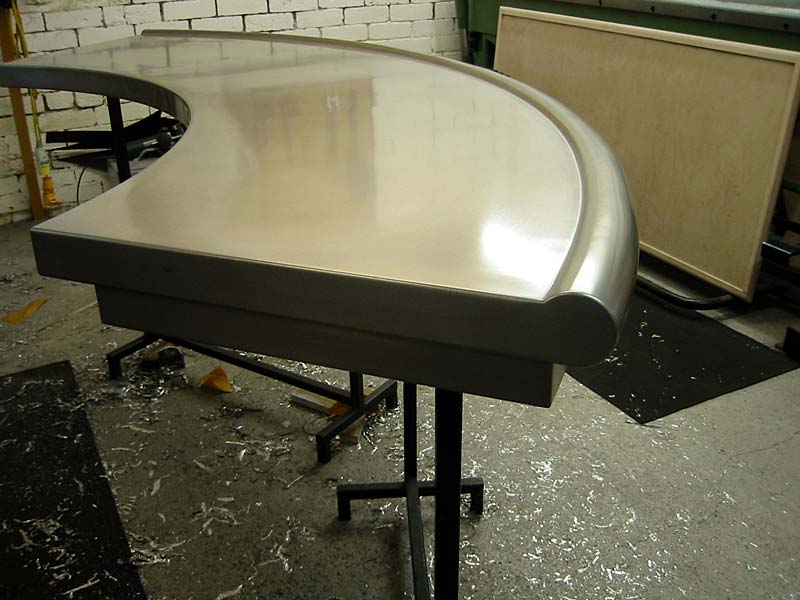 A stainless steel table with a curved top