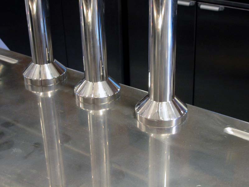 Three stainless steel pipes are lined up on a counter top