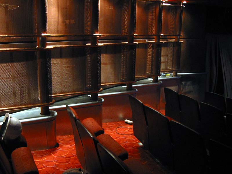 A dark auditorium with rows of seats and a red carpet
