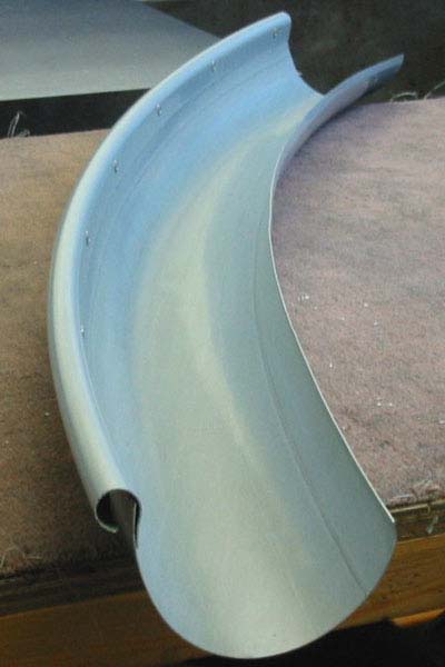 A curved piece of metal is sitting on a wooden table