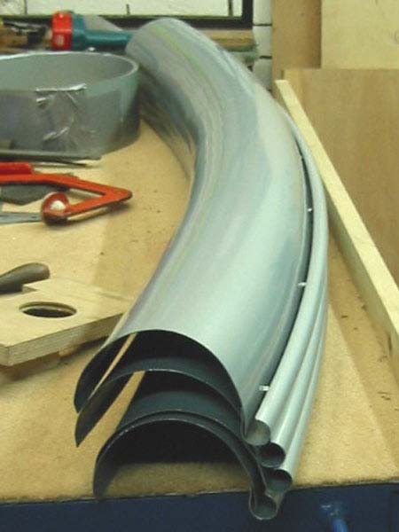 A stack of metal pipes sitting on top of a wooden table