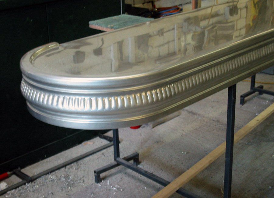 A metal bar is sitting on top of a wooden table.