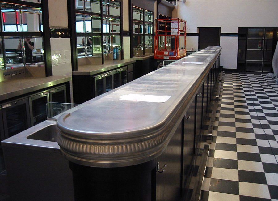 A long bar in a restaurant with a checkered floor