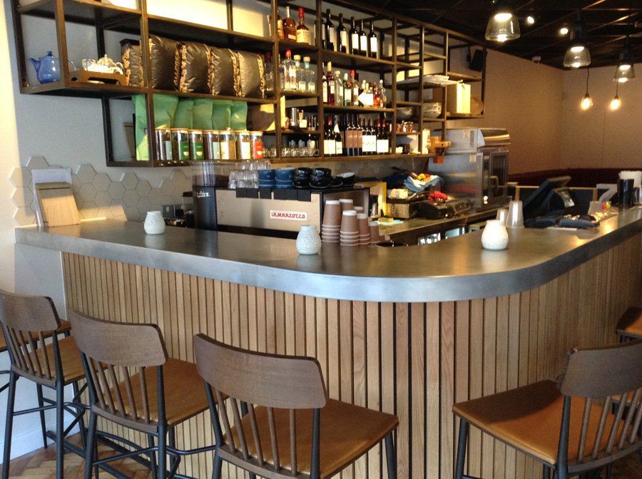 A bar in a restaurant with wooden chairs