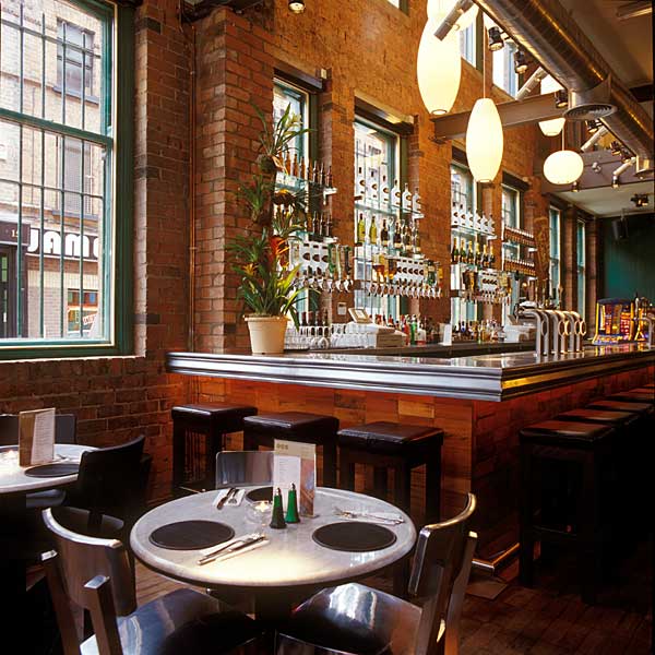 A restaurant with tables and chairs in front of a bar that says jani