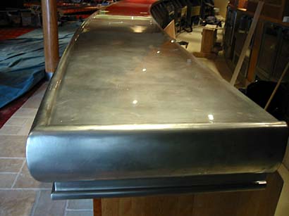 A stainless steel counter top is sitting on top of a wooden table.