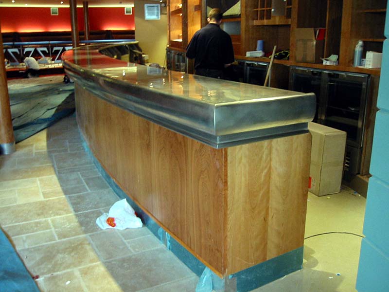 A long wooden bar with a stainless steel counter top