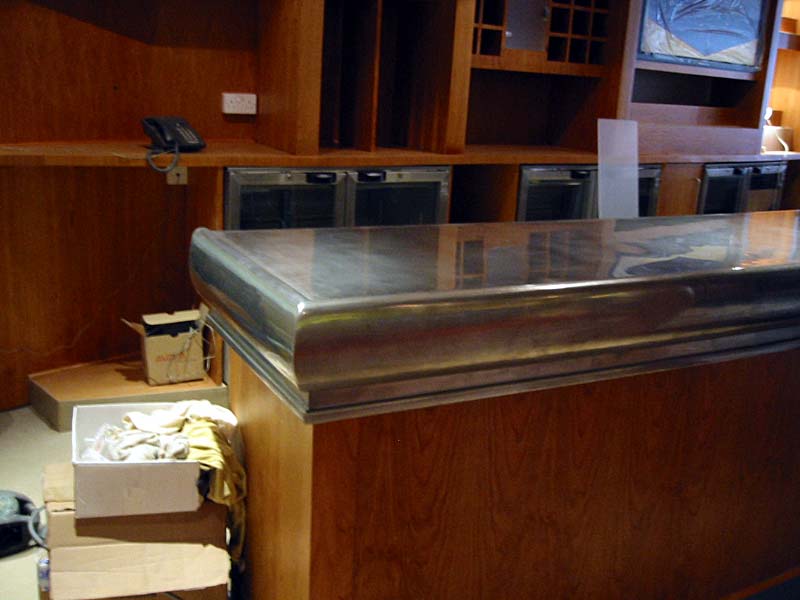 A kitchen with a stainless steel counter top and wooden cabinets