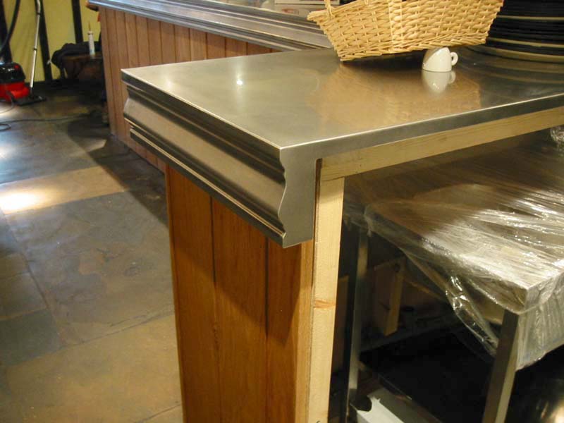 A wicker basket sits on top of a stainless steel counter top
