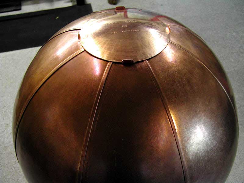A copper ball with a lid on top of it