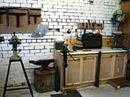 A workshop with a lot of tools and a brick wall.
