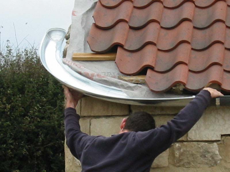 A man is working on the roof of a building