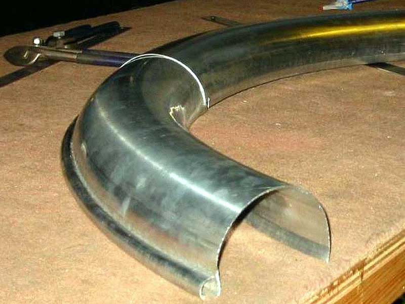 A metal pipe is sitting on a wooden table