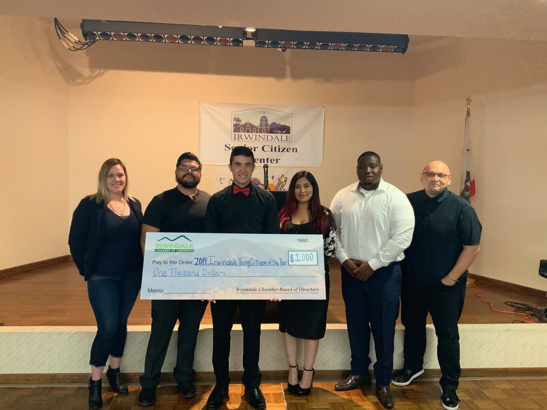 A group of people standing next to each other holding a large check.